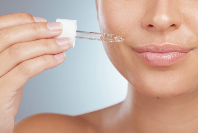 woman putting on face serum to prevent acne breakouts